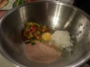 Egg, chopped peppers, grated onion, bread crumbs in bowl